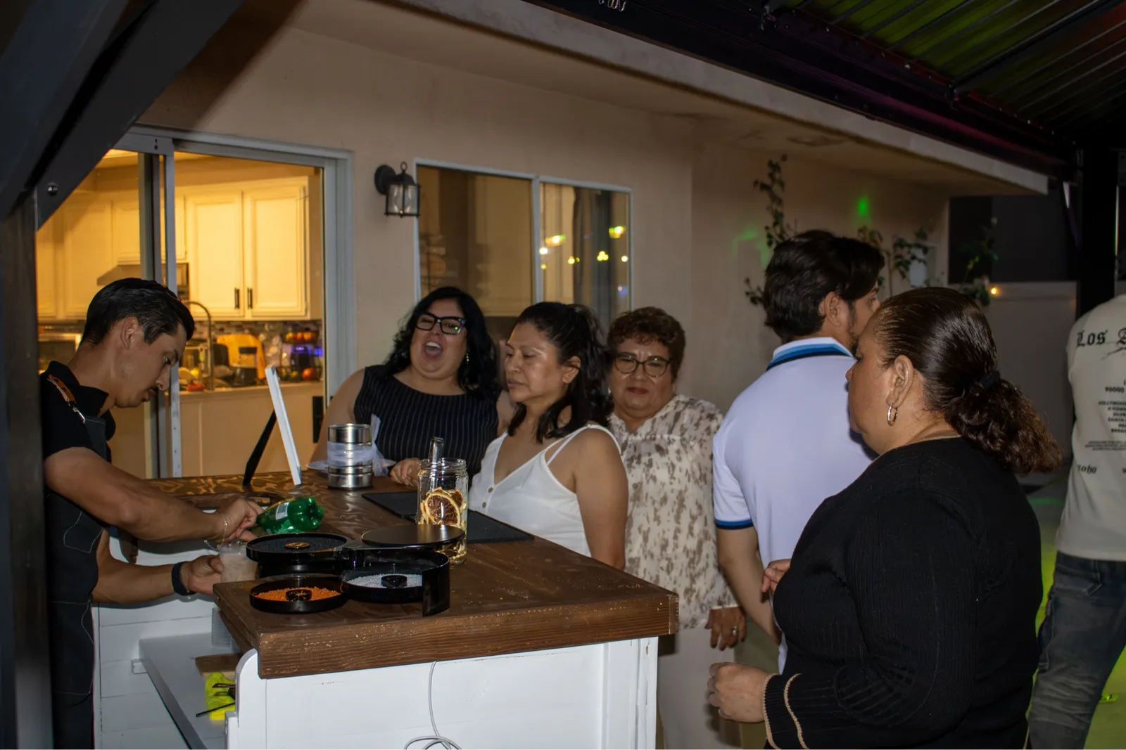 Guests gathered around the Golden Hour bar at a backyard party